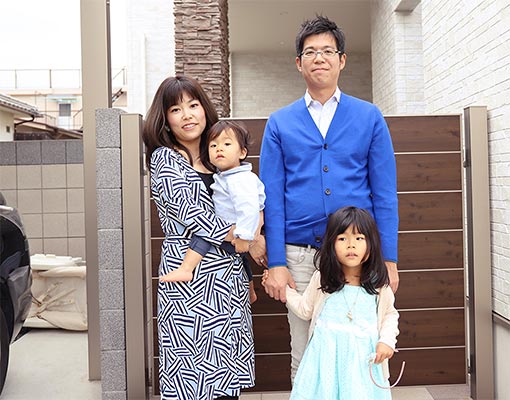 家の前で家族4人で記念撮影